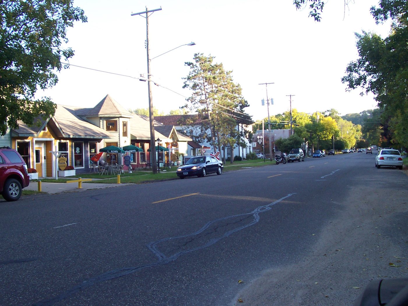 Historic village street in Afton, Minnesota, with small shops under mature trees